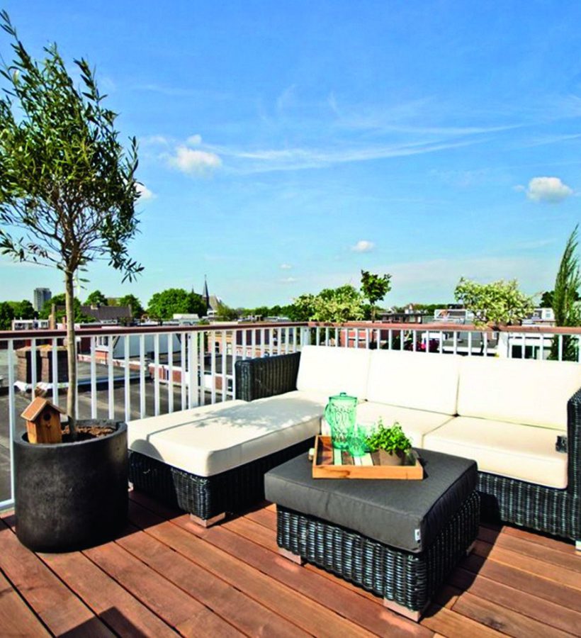 Compacte loungeset op een balkon met uitzicht over de stad