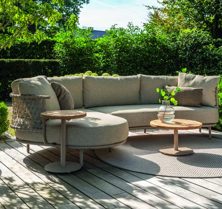 Ronde loungebank met bijzettafels op een houten vlonder